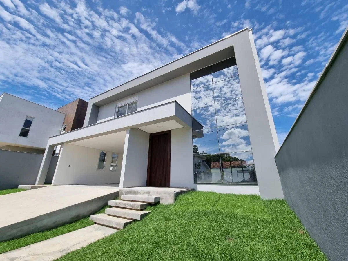 Imagem mostra uma casa de alto padrao de dois andares, com vidros espelhados a frente